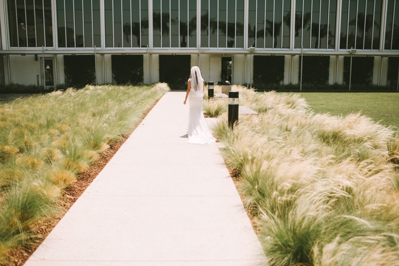 bride walking next to tall grass