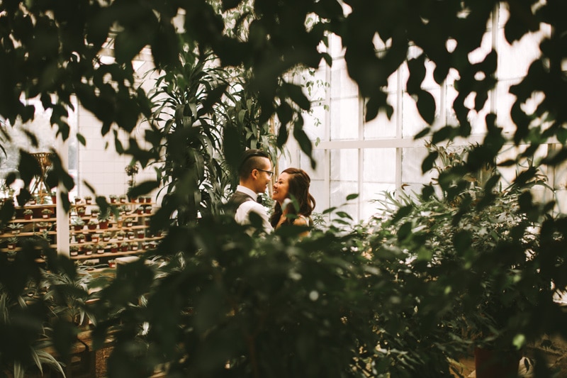 couple snuggling in greenhouse