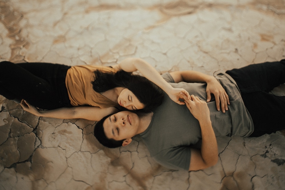 couple laying on a dry lake bed