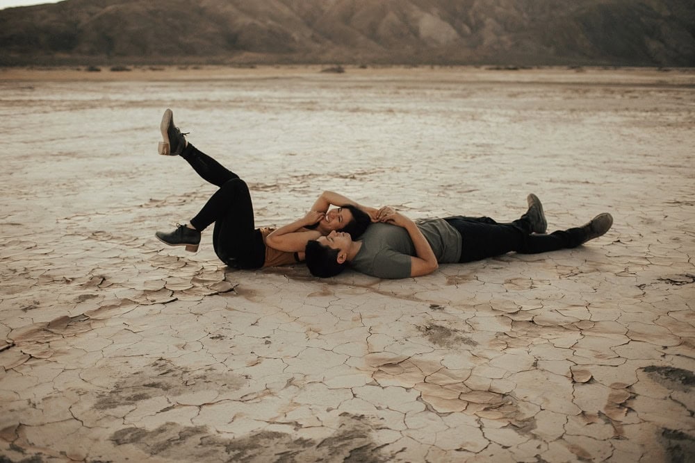 couple laying on a dry lake bed