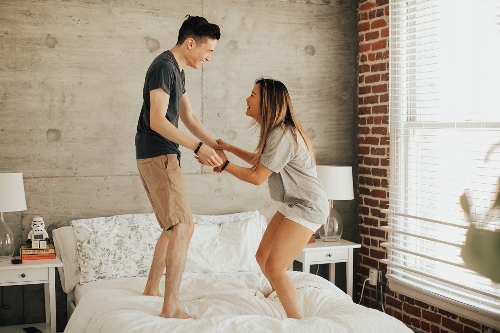 couple jumping on the bed