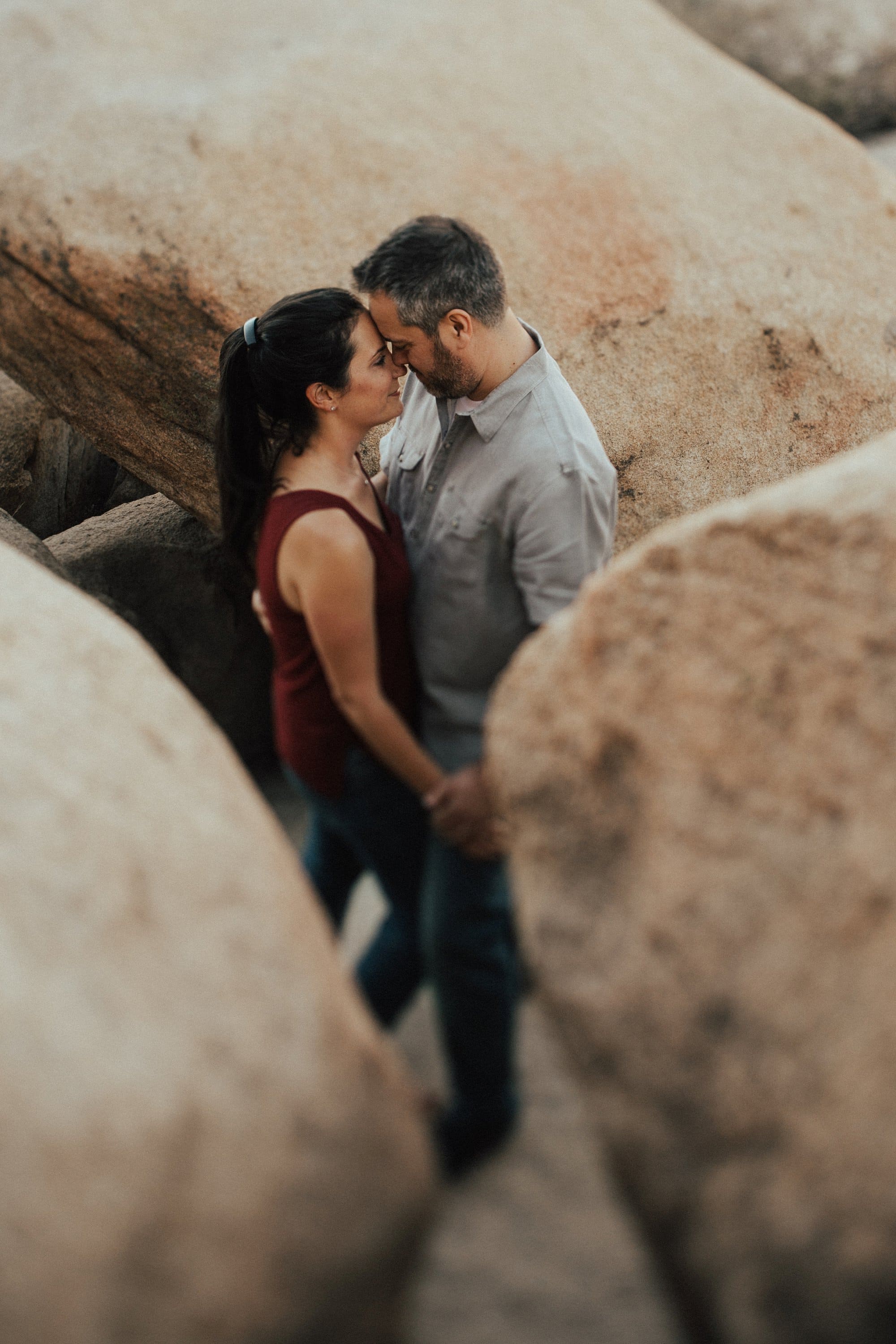 couple embracing in between boulder rocks