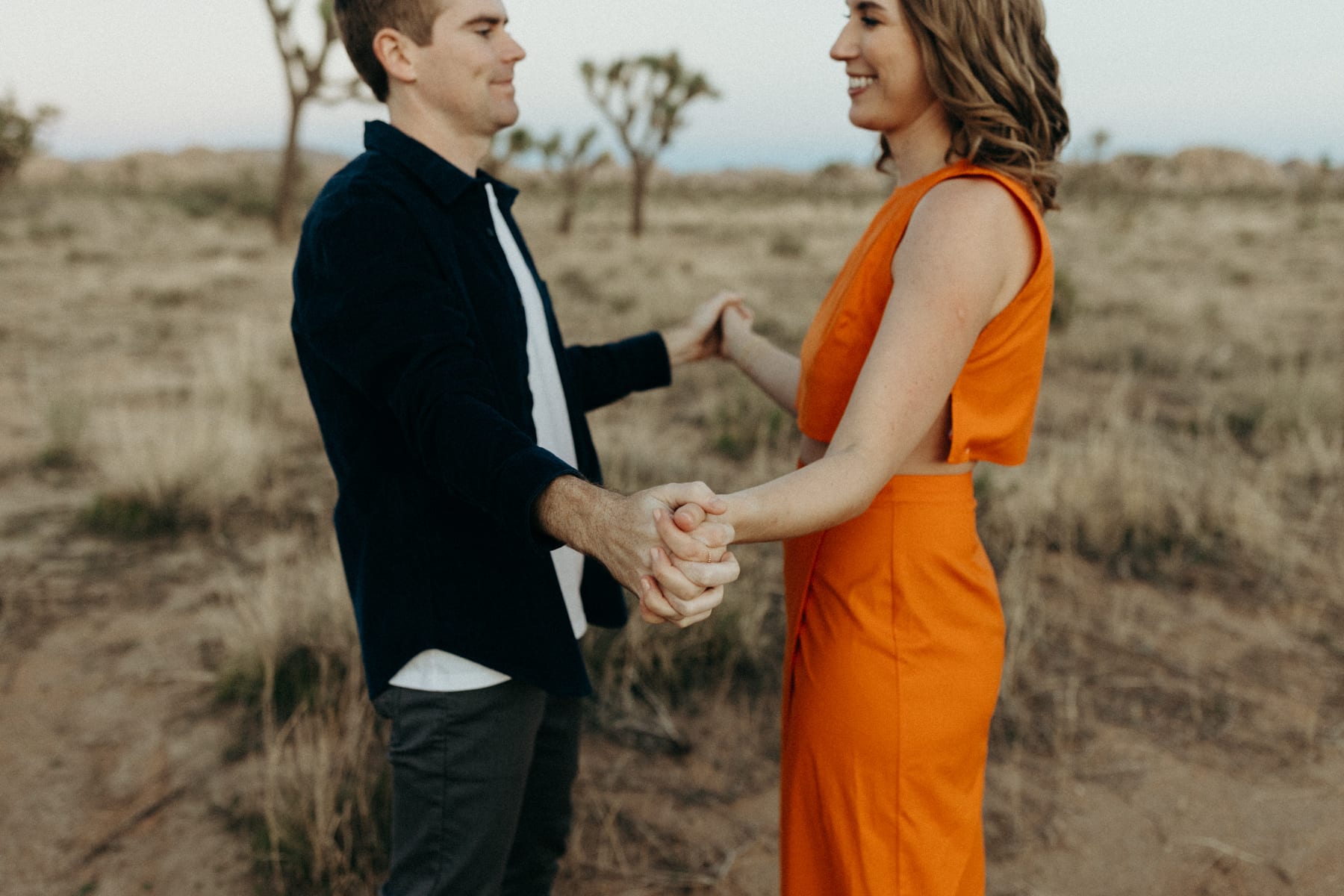 couple holding hands in with a desert background